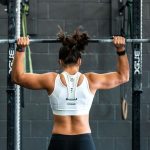 woman shoulder pressing a barbell