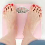 girl standing on pink scale