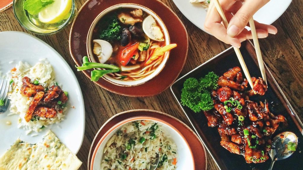 woman with chopsticks eating asian food