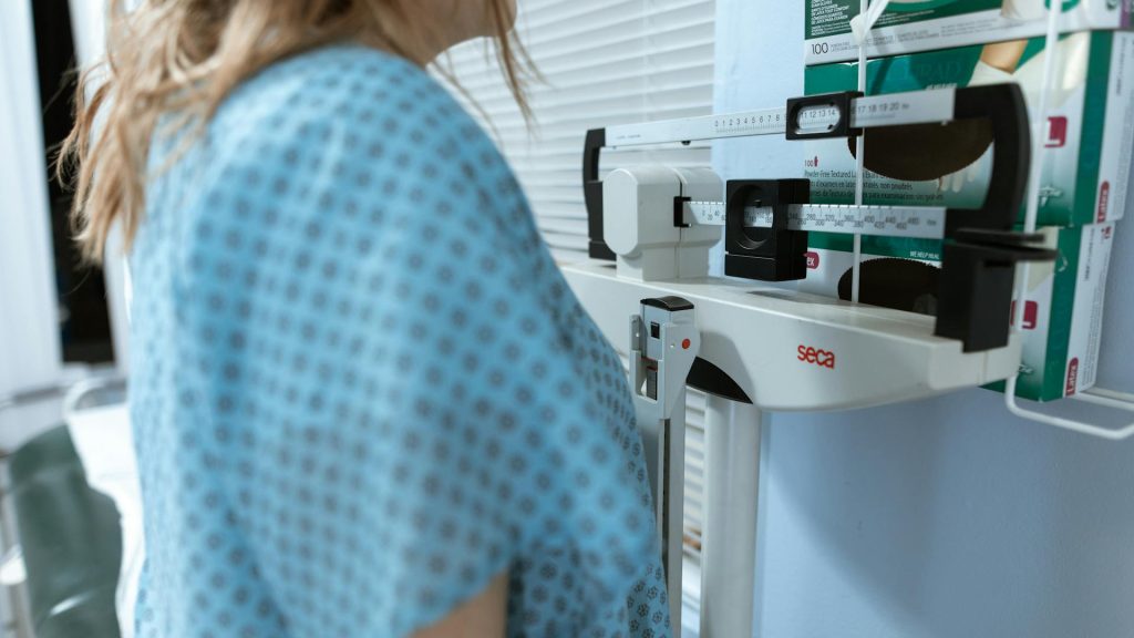 Woman in blue gown on stadiometer
